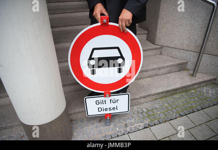 Stuttgart, Germania. 28 Luglio, 2017. Juergen Resch, Presidente federale tedesco di organizzazione ambientale "Umwelthilfe' può essere visto in posa con un segno di traffico la lettura "si applica per i Diesel' prima condanna presso la corte distrettuale di Stoccarda, Germania, 28 luglio 2017. Il tedesco della Organizzazione Ambientale "Umwelthilfe' ha lanciato una denuncia contro lo stato del Baden-Wuerttemberg e la sua aria di qualità del piano di conservazione, che farà diventare legali il 1 gennaio 2018. Foto: Marijan Murat/dpa/Alamy Live News Foto Stock