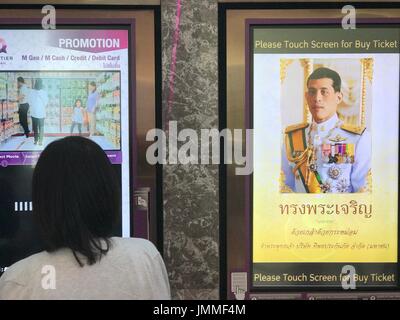 Una donna sta in piedi di fronte ad un ritratto del re di Thailandia Maha Vajiralongkorn a un cinema a Bangkok, Thailandia, 23 luglio 2017. Il nuovo monarca celebra il suo sessantacinquesimo compleanno il 28 luglio 2017. - Nessun filo SERVICE - foto: Christoph Sator/dpa Foto Stock