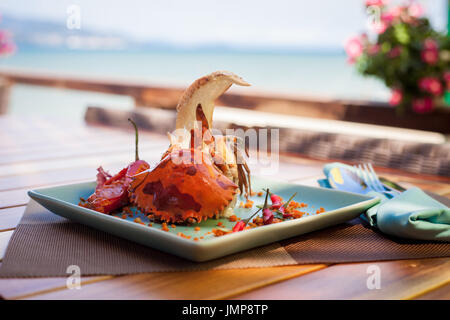 Fritti granchio di mare servito con lattuga, pane e salsa di peperoncino sulla spiaggia Foto Stock