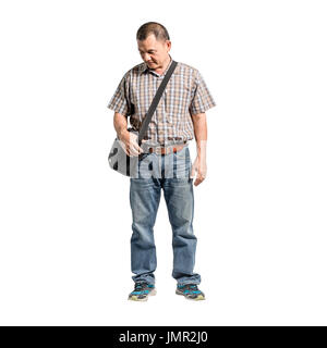 Ritratto di un felice uomo maturo in piedi di Scott shirt e jeans blu guardando al lato inferiore sinistro. Isolato di lunghezza completa su sfondo bianco con c Foto Stock