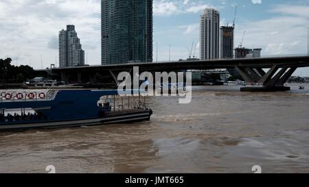 Navetta per Asiatique Fiume Chao Phraya sotto il Sathorn ponte Taksin vista dal Wat Yannawa Mekhala Pier Bangkok in Thailandia Foto Stock