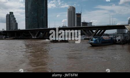 Navetta per Asiatique Fiume Chao Phraya sotto il Sathorn ponte Taksin vista dal Wat Yannawa Mekhala Pier Bangkok in Thailandia Foto Stock