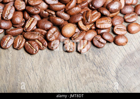Naturale di fresco il caffè torrefatto in grani oltre a trama backgr in legno Foto Stock