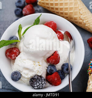 Gelato alla vaniglia scoop con frutti di bosco freschi, primo piano Foto Stock