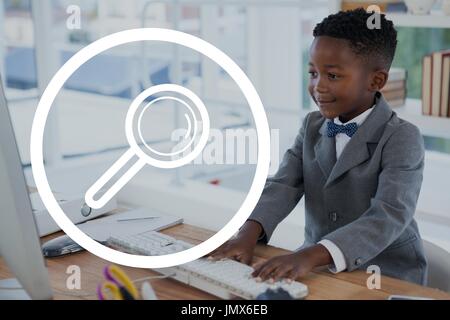 Digital composito di lenti di ingrandimento icona contro ufficio kid boy utilizzando un computer in background Foto Stock