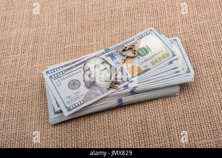 Chiave retrò e fascio di US dollar su una tela di canapa Foto Stock