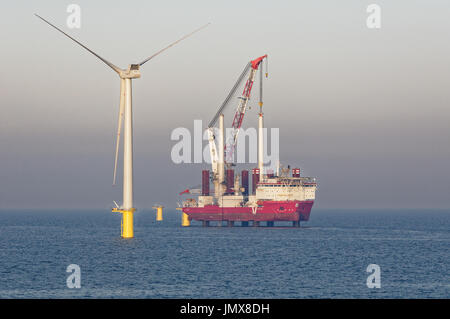 Il jack-up Crane nave MPI scoperta solleva una turbina eolica montante di sollevamento in Rampion per centrali eoliche offshore, Inghilterra. Foto Stock