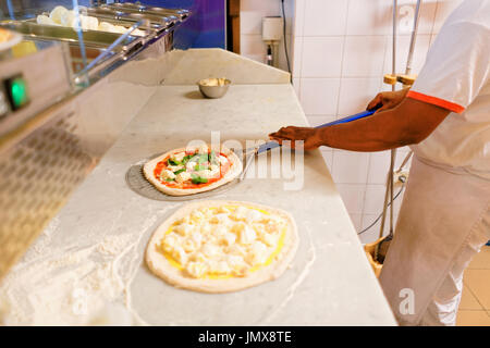 Preparazione di pizze in pizzeria ristorante, Firenze, Toscana, Italia. Foto Stock