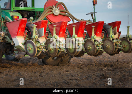 Close up della seminatrice attaccato al trattore nel campo. Macchine agricole per la molla lavora semina,la semina Foto Stock