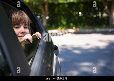 Premurosa ragazza adolescente guardando attraverso la finestra auto Foto Stock