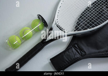 Angolo di Alta Vista della racchetta da tennis da palle nel contenitore su sfondo bianco Foto Stock
