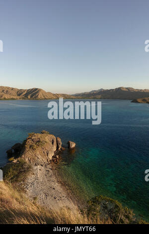 La vista dalla cima di una montagna a Gili Lawa affacciato su altre montagne lungo la costa con il blu turchesi acque dell'oceano in tra in Flores, in Foto Stock