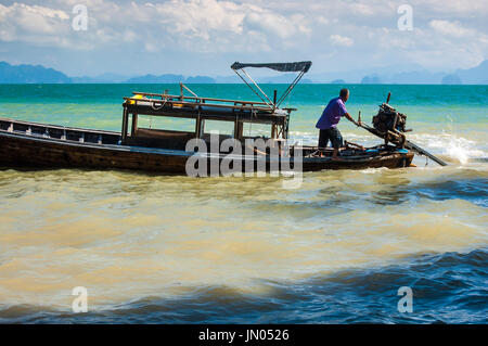 Baia di Phang Nga, Tailandia - 1 Dicembre 2013: Boatman manovre barca long-tail appena fuori isola di Ko Yao Noi in Phang Nga Bay nei pressi di Phuket Foto Stock