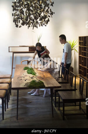 (170729) -- HANGZHOU, luglio 29, 2017 (Xinhua) -- i clienti a visitare lo showroom di YM1978 in Hangzhou, est della Cina di Provincia dello Zhejiang, 29 luglio 2017. Il marchio è stato stabilito da un padre con sua figlia nel 2009, utilizzando rotto o difettoso il legno come materiale per i suoi mobili. Della Cina di industria di mobili è abbracciando una nuova ondata di designer indipendenti marchi, soprattutto in città come Pechino, Shanghai e Hangzhou. La nuova generazione di progettisti attribuisce più importanza sull'espressione contemporanea di elementi Cinesi, aggiungendo slancio creativo per l'industria del mobile in Cina. (Xinhua/Weng Foto Stock