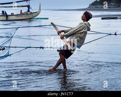 Airkuning, Bali, Indonesia. 29 Luglio, 2017. Un pescatore in Kuning, un musulmano villaggio di pescatori sull'angolo sud-ovest di Bali, raggio in una rete da pesca che era stata prevista da canoe outrigger dal villaggio. Gli abitanti di un villaggio detto loro regolare delle catture di pesce è stato in diminuzione per diversi anni e che sono alcune mattine che tornano a riva con aver catturato un pesce. Credit: Jack Kurtz/ZUMA filo/Alamy Live News Foto Stock