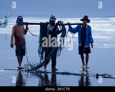 Airkuning, Bali, Indonesia. 29 Luglio, 2017. I pescatori roll up della rete dopo alaggio in in Kuning, un musulmano villaggio di pescatori sull'angolo sud-ovest di Bali. Gli abitanti di un villaggio detto loro regolare delle catture di pesce è stato in diminuzione per diversi anni e che sono alcune mattine che tornano a riva con aver catturato un pesce. Credit: Jack Kurtz/ZUMA filo/Alamy Live News Foto Stock