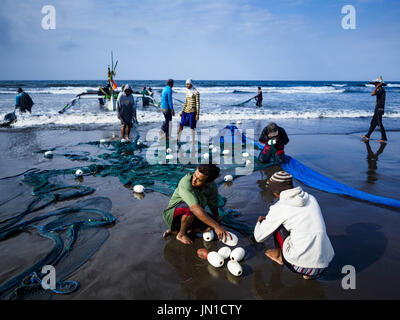 Airkuning, Bali, Indonesia. 29 Luglio, 2017. Gli abitanti di un villaggio di riparare e arrotolare la loro rete da pesca dopo il traino in in Kuning, un musulmano villaggio di pescatori sull'angolo sud-ovest di Bali. Gli abitanti di un villaggio detto loro regolare delle catture di pesce è stato in diminuzione per diversi anni e che sono alcune mattine che tornano a riva con aver catturato un pesce. Credit: Jack Kurtz/ZUMA filo/Alamy Live News Foto Stock