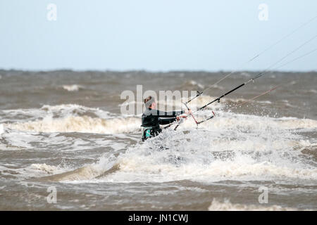 Southport, Merseyside, 29 luglio 2017. Regno Unito Meteo. Kite boarder in testa nel mare d'Irlanda per cavalcare le onde su una marea sulla spiaggia di Southport nel Merseyside. Blustery 25mph venti fanno vicino le condizioni perfette per riempire le vele a questo ben noto kite boarding hotspot. Credito: Cernan Elias/Alamy Live News Foto Stock