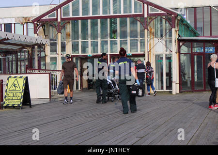 Blackpool Lancashire, Regno Unito. 29 Luglio, 2017. I paramedici evacuare infortunato su di una barella fro Pier Jam che si terrà al North Pier di Blackpool questa sera Credito: David Billinge/Alamy Live News Foto Stock