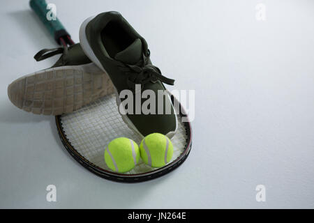 Angolo di Alta Vista della calzatura sportiva con palla da tennis e delle racchette su sfondo bianco Foto Stock