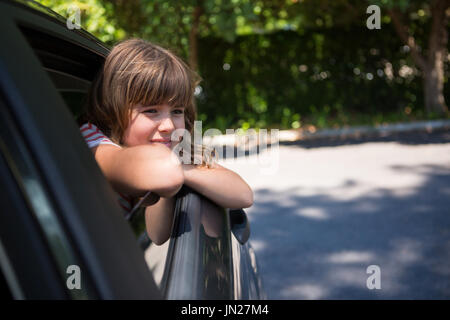 Premurosa ragazza adolescente guardando attraverso la finestra auto Foto Stock