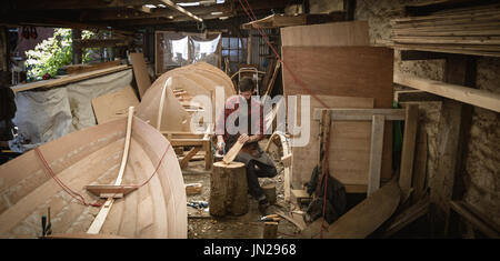 Carpenter il taglio di log di legno in officina Foto Stock