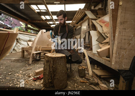 Carpenter il taglio di log di legno in officina Foto Stock