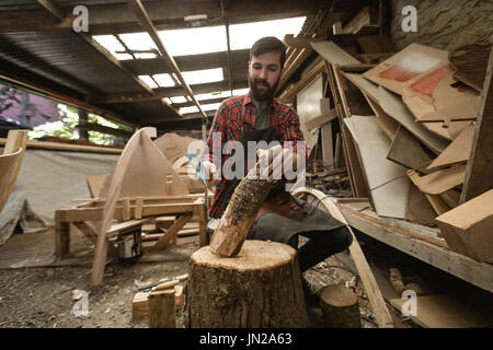 Carpenter il taglio di log di legno in officina Foto Stock