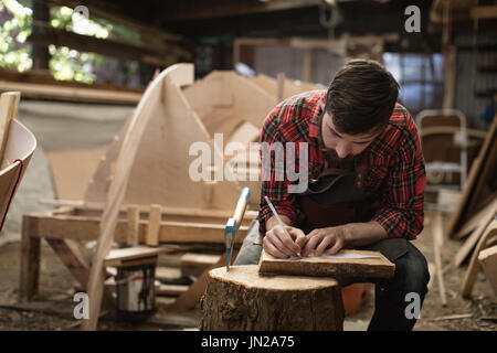 Falegname attento lavoro in officina Foto Stock