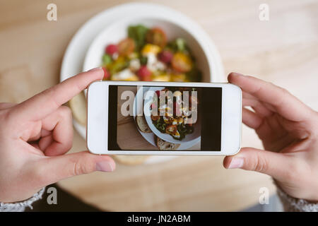 Close-up di donna prendere una fotografia del suo pasto Foto Stock