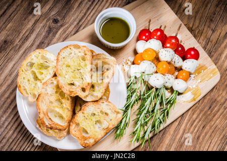 Il pomodoro formaggio e pane antipasti su spiedini di rosmarino Foto Stock