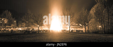 Persone celebrazione intorno grande enorme fuoco tradizionale evento. Foto Stock