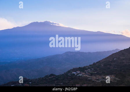 Etna Sicilia, vista dei raggi del tramonto che tramonta sull'Etna e sulle colline che circondano Taormina, Sicilia. Foto Stock