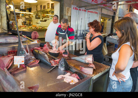 Mercato del pesce siciliano, vista della gente che si accosta ad acquistare bistecche di tonno fresco nel mercato del pesce di Ortigia (Ortigia) Siracusa, Sicilia. Foto Stock