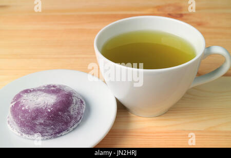 A caldo di tè verdi giapponesi con dolci chiamati Daifuku servita su un tavolo di legno Foto Stock