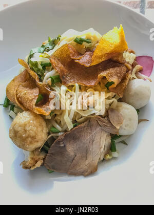 Asian Street Food. Primo piano a base di noodle all'uovo con miele rosso arrosto di maiale (char siu, char siew) e polpette di pesce e fritti gnocchi. Foto Stock