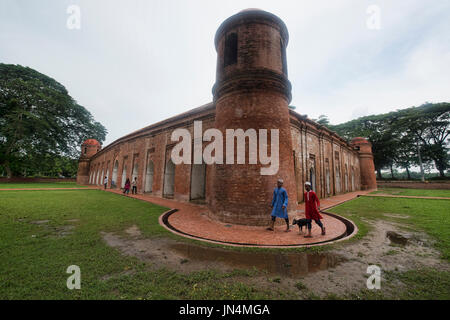 Ragazzi a piedi le loro capre al Shait Gumbad sessanta moschea a cupola, Bagerhat, Bangladesh Foto Stock