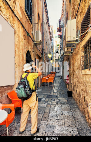 Uomo di scattare le foto di stretto street nella città vecchia di Dubrovnik, Croazia Foto Stock