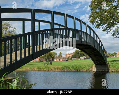 Smart nuovo, unico arco in legno passerella pedonale oltre alla peschiera in motivi di Doddington Hall Estate, Lincolnshire, England, Regno Unito Foto Stock