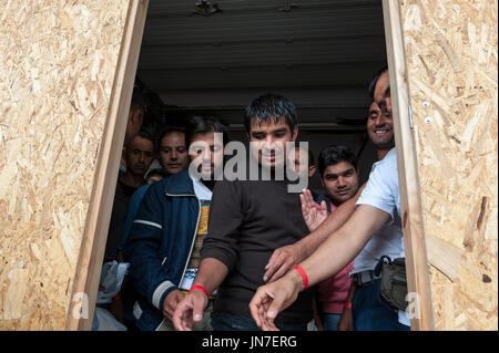 Passau, Germania - 1 agosto 2015: siriano uomini di rifugiati in attesa di registrazione in un accampamento di Passau, Germania Foto Stock