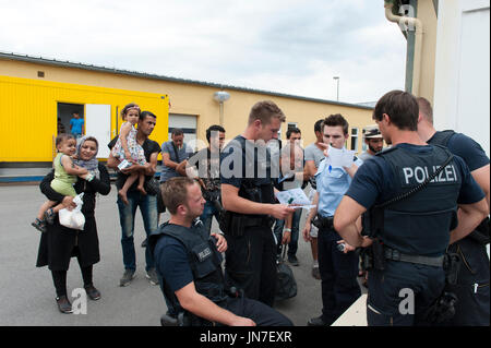 Passau, Germania - 1 agosto 2015: La polizia di prendere le informazioni dai rifugiati in temporanea del centro di registrazione per i migranti e i rifugiati. Foto Stock