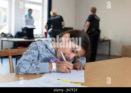 Passau, Germania - 2 Agosto 2015 : giovane ragazza di rifugiati dalla Siria all'area di registrazione in Passau, Baviera. Sta scrivendo una lettera. Foto Stock