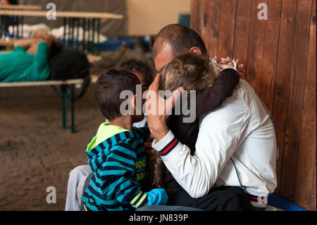 Passau, Germania - 2 Agosto 2015: Padre e i suoi tre bambini arrivano alla registrazione dei rifugiati centro in Passau, Germania meridionale. Foto Stock