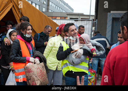 Monaco di Baviera, Germania - 7 Settembre 2015: un gruppo di rifugiati siriano con un bimbo piccolo sono molto felice per arrivare alla zona di registrazione di Monaco di Baviera. Foto Stock