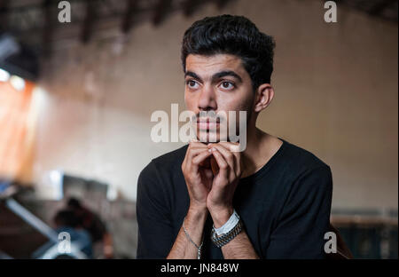Passau, Germania - 2 Agosto 2015: giovane rifugiato siriano in un accampamento di Passau, Germania. Egli è desperat e attesa per la sua registrazione. Foto Stock