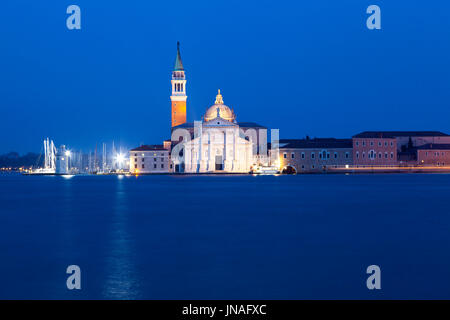 San Giorgio Maggiore monastero benedettino , Venezia, Veneto Italia al blue ora visualizzati tramite l'acqua da San Marco con un sentiero di luce da una barca Foto Stock