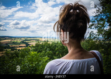 Donna che guarda ad ovest attraverso Wenlock Edge. Un concetto cercando, come guardando in lontananza, guardando al futuro. Shropshire, Regno Unito. Foto Stock