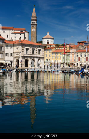 Piran Slovenia con porto interno foderato con barche e Tartini Square e Cattedrale di San Giorgio e il Battistero con torre campanaria si riflette nell'acqua Foto Stock