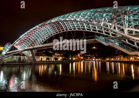 Vista notturna del ponte di pace sul fiume Kura, Tbilisi, Georgia Foto Stock