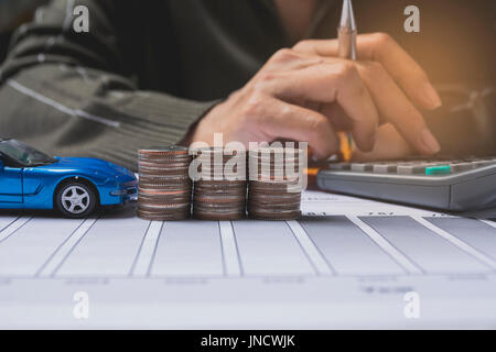 Mano premendo il pulsante calcolatrice con auto di assicurazione e servizi auto concetto. Concetto aziendale. Assicurazione auto concetto. Foto Stock